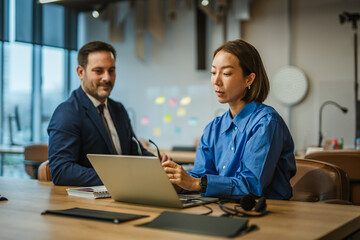 Business colleagues collaborating on laptop during office meeting