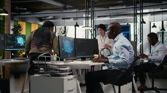 AI startup office personnel automating workflows using neural networks on PC. African american man and team leader refine deep learning models for faster processing, camera A