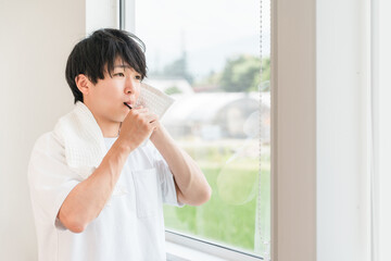 Fototapeta premium Young Asian man brushing his teeth in the morning (dental care, toothbrush, whitening, oral care) 