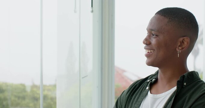 African American man in twenties reacting to palm tree view, smiling laughing at window, copy space