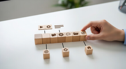 User interface design and arranging cubes to represent a simple layout using wooden cubes, symbolic icons, human hand, natural depth of field, soft blurred background, clean white desk..png