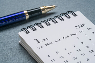 January 2026 - small spiral desktop calendar with a pen, time and business concept