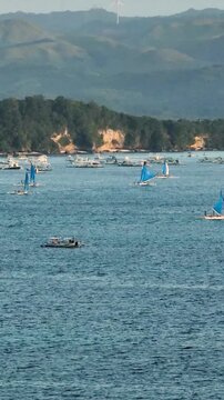 Sunset Sailing Boats and Cruise ship over the blue sea in Boracay, Philippines. Vertical view.