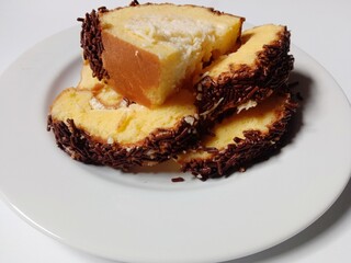 
sponge roll cake with grated cheese filling and sprinkles chocolate topping. 

