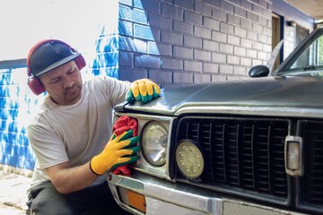 Latino man cleans his car at home