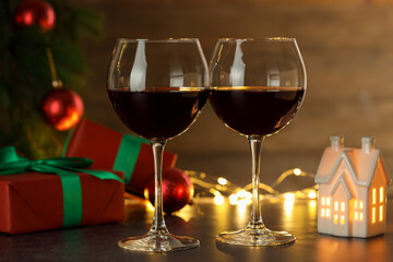 Glasses of red wine and Christmas decor on grey table