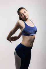 Obraz premium Young female athlete in sports outfit poses with confidence, capturing the essence of strength and determination