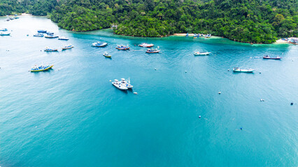 Aerial View of Ngliyeb Beach: Turquoise Ocean, Green Cliffs, and Rugged Coastline