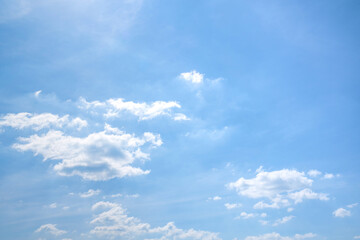 Soft white cumulus clouds spread through a bright blue sky, giving a beautiful cloud landscape with open copy space.