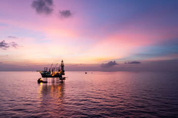 Aerial view of offshore jack up rig in a shipyard during sunset for oil and gas exploration and production.