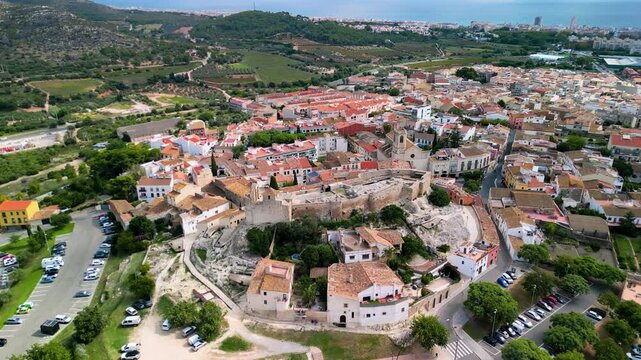 Aerial view of Castell de la Santa Creu de Calafell, a medieval fortress in Catalonia, Spain. Historic castle and stone church with panoramic views of Costa Dorada.