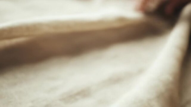 Close up of beige fabric texture with soft folds and subtle details