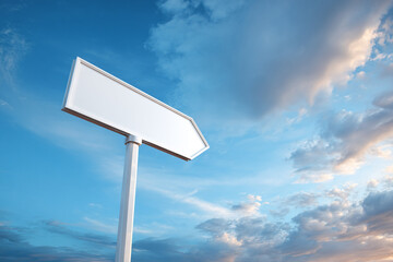 Blank, white hexagonal directional sign pointing left, mounted on a pole against a dramatic, sunny blue sky with clouds.