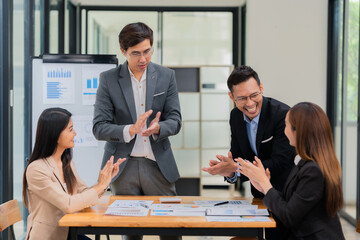 Group of business people discussing business plan in office conference room. Project planning, creative brainstorming, discussing ideas, using documents, digital devices.