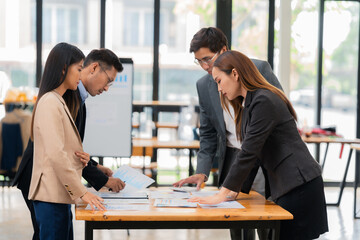 Group of business people discussing business plan in office conference room. Project planning, creative brainstorming, discussing ideas, using documents, digital devices.