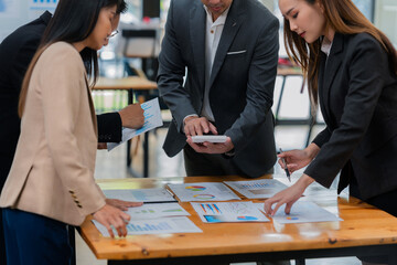 Group of business people discussing business plan in office conference room. Project planning, creative brainstorming, discussing ideas, using documents, digital devices.