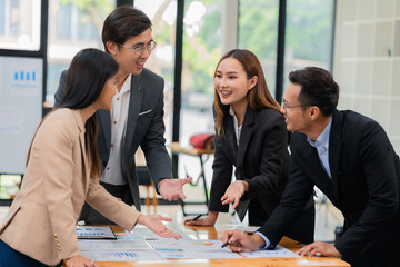 Group of business people discussing business plan in office conference room. Project planning, creative brainstorming, discussing ideas, using documents, digital devices.