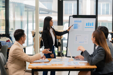 Group of business people discussing business plan in office conference room. Project planning, creative brainstorming, discussing ideas, using documents, digital devices.
