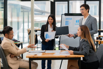 Group of business people discussing business plan in office conference room. Project planning, creative brainstorming, discussing ideas, using documents, digital devices.
