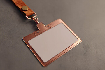 Elegant, blank copper-toned metal ID badge holder with a white card space lying on a textured gray background, close-up shot.