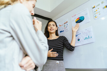 Business team analyzing data and marketing strategy in modern office, brainstorming ideas for project success using laptops and charts, teamwork collaboration for corporate growth