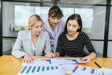 Business team analyzing data and marketing strategy in modern office, brainstorming ideas for project success using laptops and charts, teamwork collaboration for corporate growth