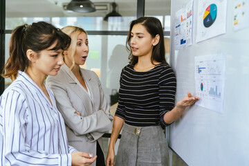 Business team analyzing data and marketing strategy in modern office, brainstorming ideas for project success using laptops and charts, teamwork collaboration for corporate growth