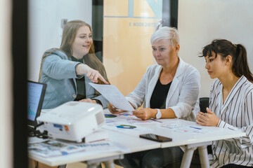 Business team analyzing data and marketing strategy in modern office, brainstorming ideas for project success using laptops and charts, teamwork collaboration for corporate growth