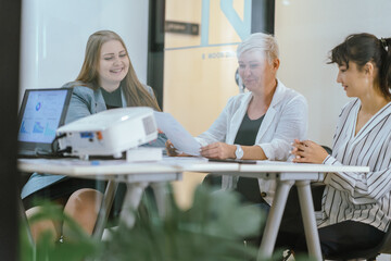 Business team analyzing data and marketing strategy in modern office, brainstorming ideas for project success using laptops and charts, teamwork collaboration for corporate growth
