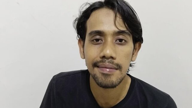 close-up of a man giving a Shh or hush sign then smiling at the end. indicating a silent order or conveying a certain secret