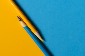 Teal and yellow colored pencil on the same colored paper