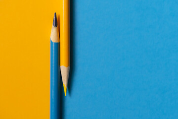 Teal and yellow colored pencil on solid paper