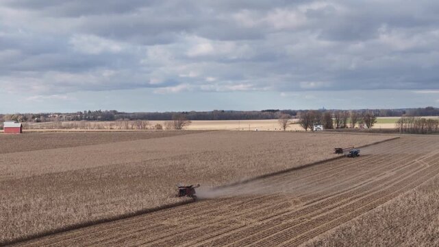Aerial view of two combines moving through a corn field harvesting corn