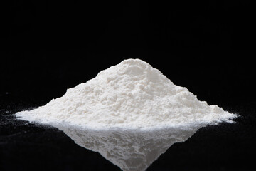 heap of white flour isolated on black background