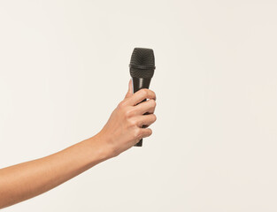 female hand with a black microphone on a white background