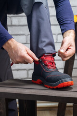 Worker putting on shoes for work. Safety work concept.