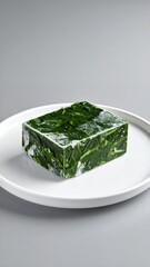Green Gelatin Cube with Herbs on White Plate.