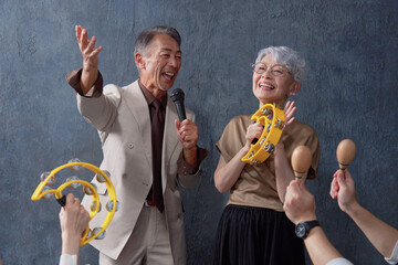 カラオケをするシニアの男性と女性　黒背景