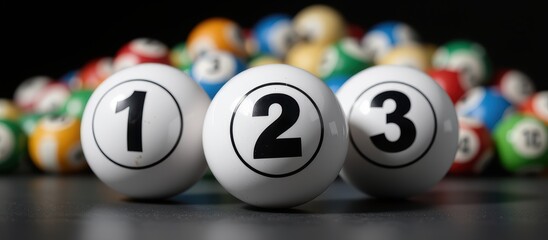Three numbered bingo balls in focus with colorful balls blurred in the background.