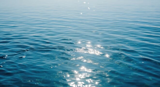 A serene blue ocean with gentle ripples and a few small waves.