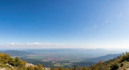 Obraz premium A panoramic view of a vast, open landscape with a clear blue sky and distant mountains.