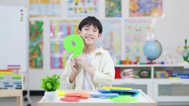 Smiling Schoolboy Learning Number Nine in Colorful Classroom