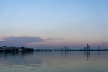 Naklejka premium Hanoi Skyline Reflected on Ho Tay, West Lake at Sunset, Vietnam