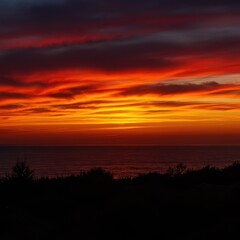 Fototapeta premium A dramatic and intense sunset featuring vibrant orange, deep red, and golden hues across a cloudy horizon, creating a fiery appearance ,majestic ,background ,dawn