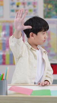 Schoolboy Refusing with Raised Hand in Classroom Side View