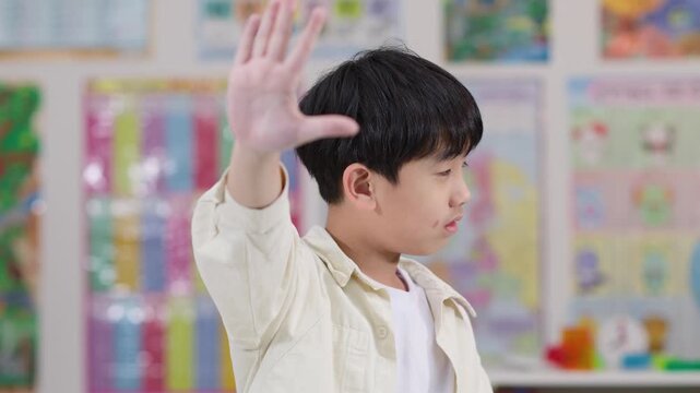 Schoolboy Refusing With Raised Hand in Classroom Side View