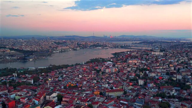 Istanbul Turkey T&uuml;rkiye aerial drone Bosphorus Strait ferry boats harbor view sunset golden hour pink sky afterglow cityscape buildings panoramic landscape skyscrapers mosque forwards pan up