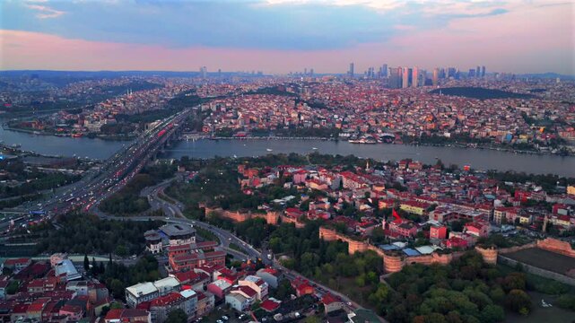 Istanbul Turkey T&uuml;rkiye aerial drone traffic cars bridge Bosphorus Strait ferry boats sunset golden hour pink sky afterglow cityscape buildings panoramic landscape skyscrapers mosque circle left