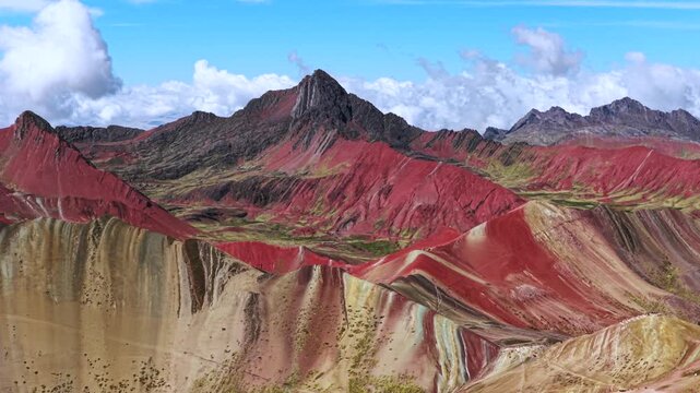 Vinicunca Rainbow Mountain Peru Per&uacute; aerial drone morning blue sky Monta&ntilde;a de Siete Colores Palccoyo clouds Peruvian Andes Red Valley striped hills seven colored Cusco Region landscape parallax circle