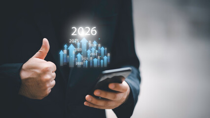 Businessman drawing digital growth arrows and bar graph with 2026 target. Futuristic concept for business goals, technology strategy, data-driven planning, success and innovation.